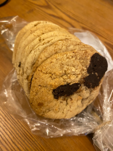row of small light coloured cookies with dark chocolate chunks visible.